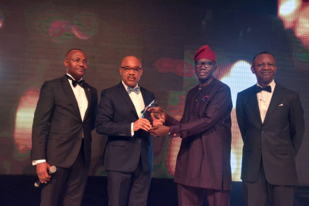 L-R: Oyewale Ariyibi, Chief Financial Officer, FBN Holdings Plc, UK. Eke, Group Managing Director, FBN Holdings Plc receiving the award from Henry Olayemi, Chairman Reward Investments & Services Limited and Frank Aigbogun, Publisher, BusinessDay.